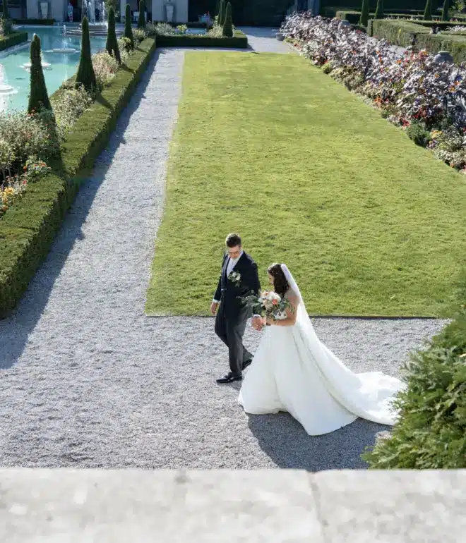 Bride and groom walking through a classic garden and waterfall